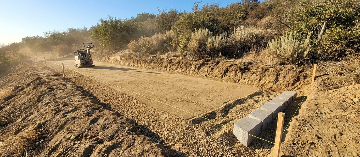 Excavated and compacted aggregate base being prepared for a new retaining wall on a Los Angeles hillside lot